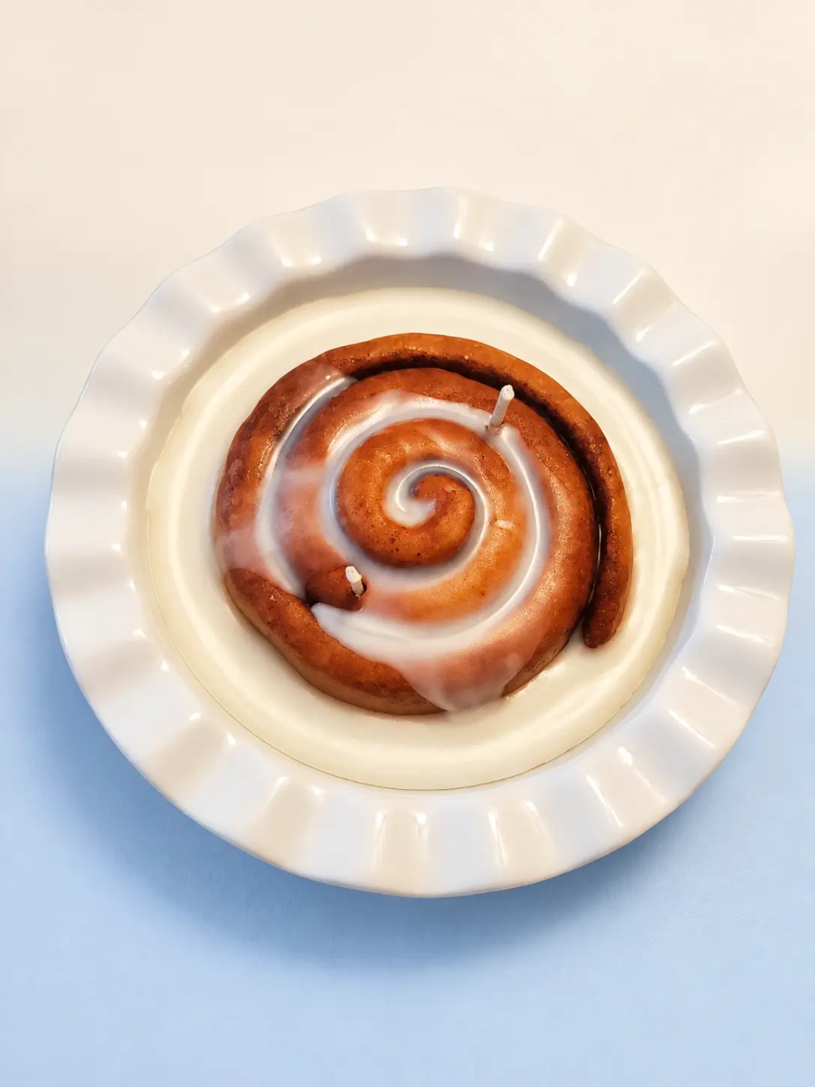 Handmade frosted cinnamon-roll candle in a reusable ceramic dish