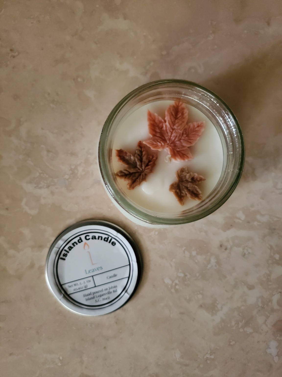 Finished jar candle decorated with wax autumn leaves